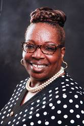 A person wearing glasses and a polka dot shirtDescription automatically generated